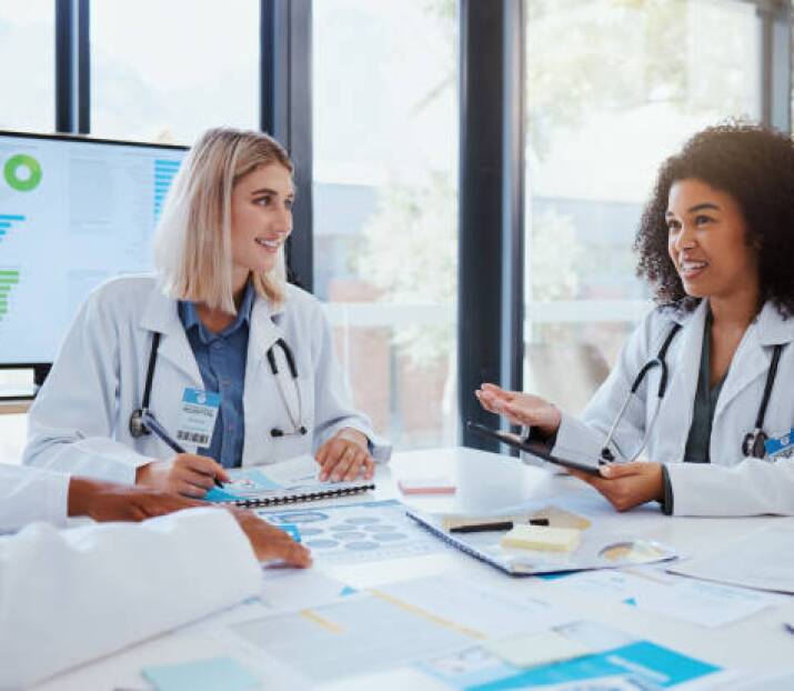 Healthcare, meeting and teamwork with a doctor and her team planning for growth, research and innovation in the medical industry. Collaboration, medicine and communication with a woman surgeon