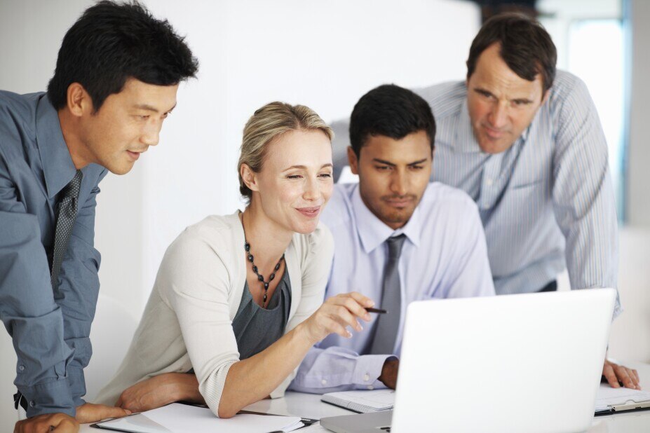 colleagues collaborate to analyze data on a laptop