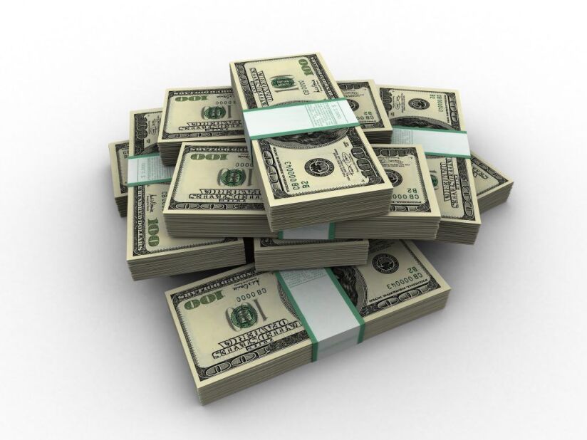 bundles of $100 bills piled on a white surface