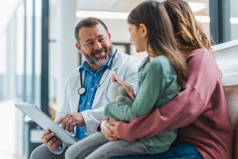 Girl patient at examination in a modern medical clinic with her parent. Emotional support during medical examination.