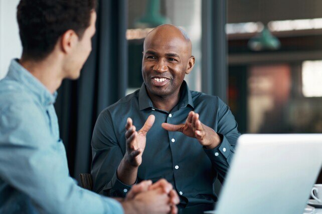 Two men discussing Epic Payer Platform and InterSystems Payer Connector in front of a laptop