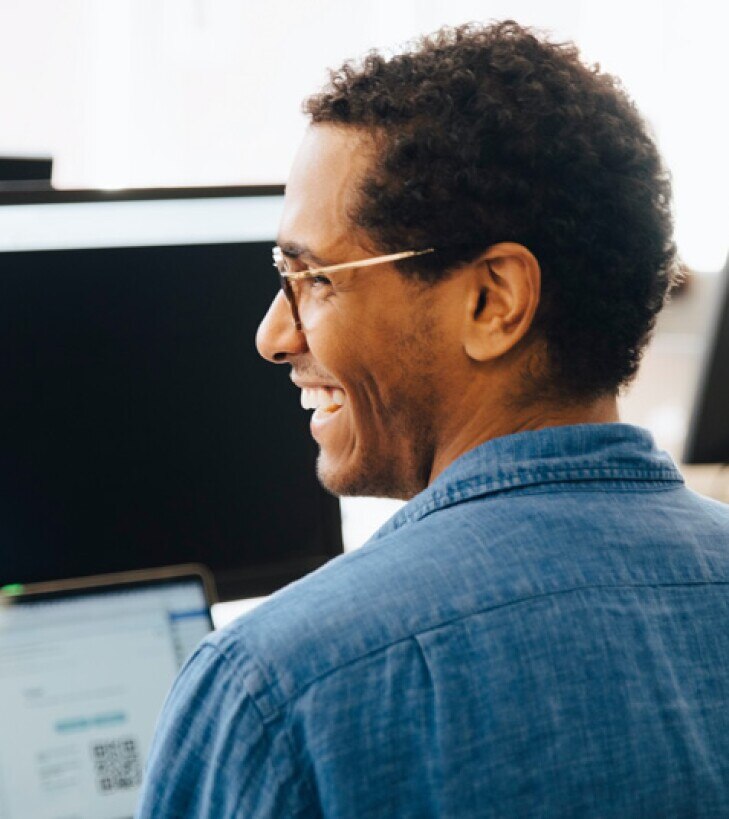 man working at his computer smiling