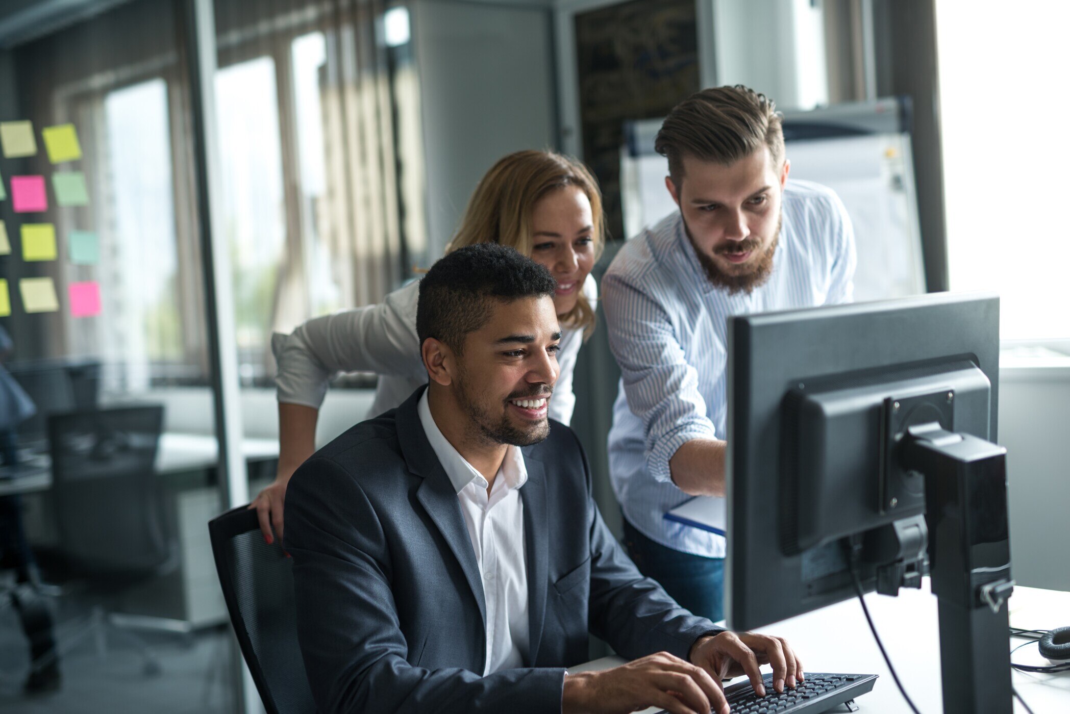 Team of businesspeople working together on a computer.