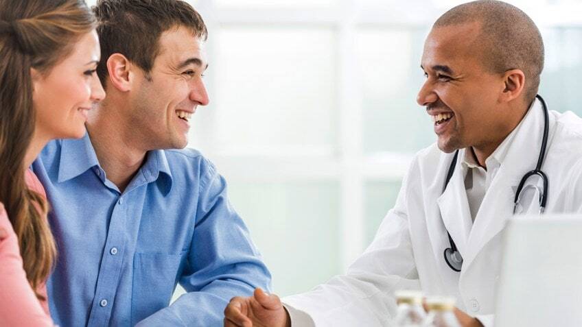 doctor speaking with a young couple