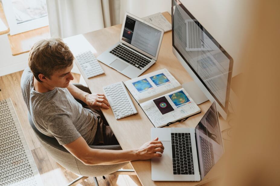 customer experience professional working on multiple computers in a home office