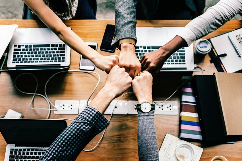 group of colleagues fist bumping showing collaboration