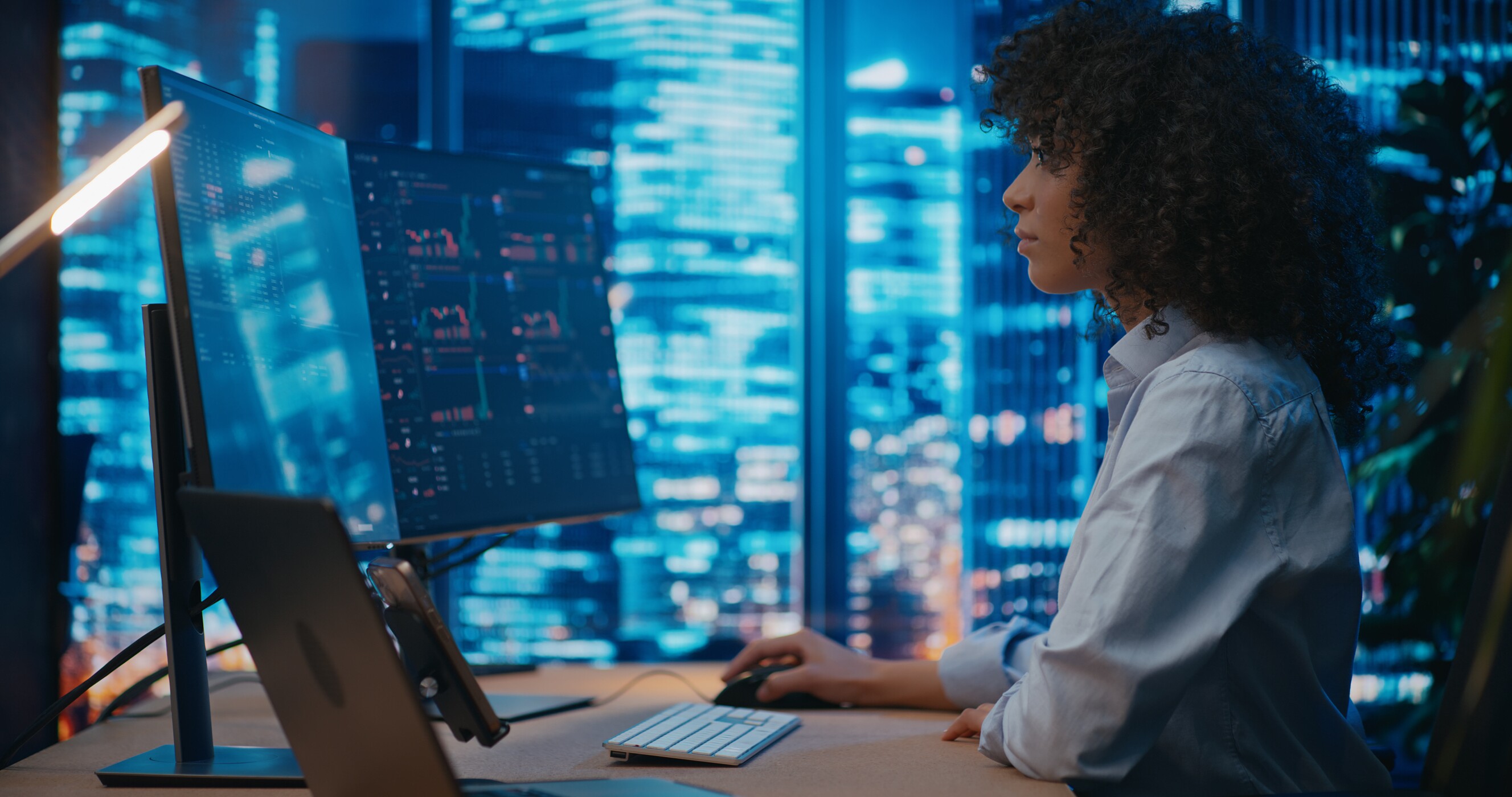 programmer/manager sits in front of computer in the office, analyzing graphs