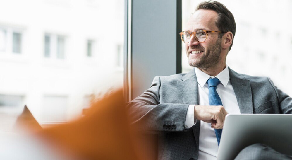 businessman with laptop near bright window