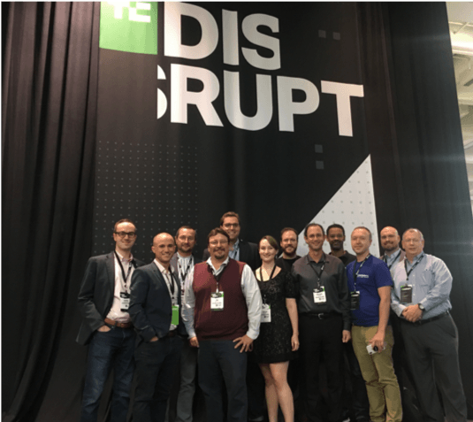 group of attendees in fron of Disrupt banner