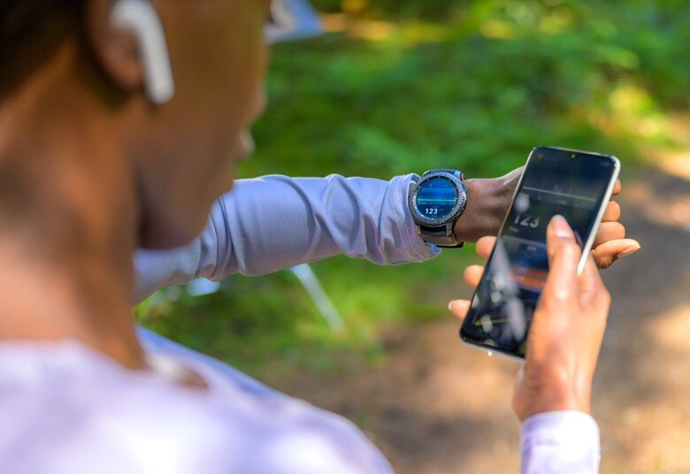 woman synching her smartwatch to her mobile phone