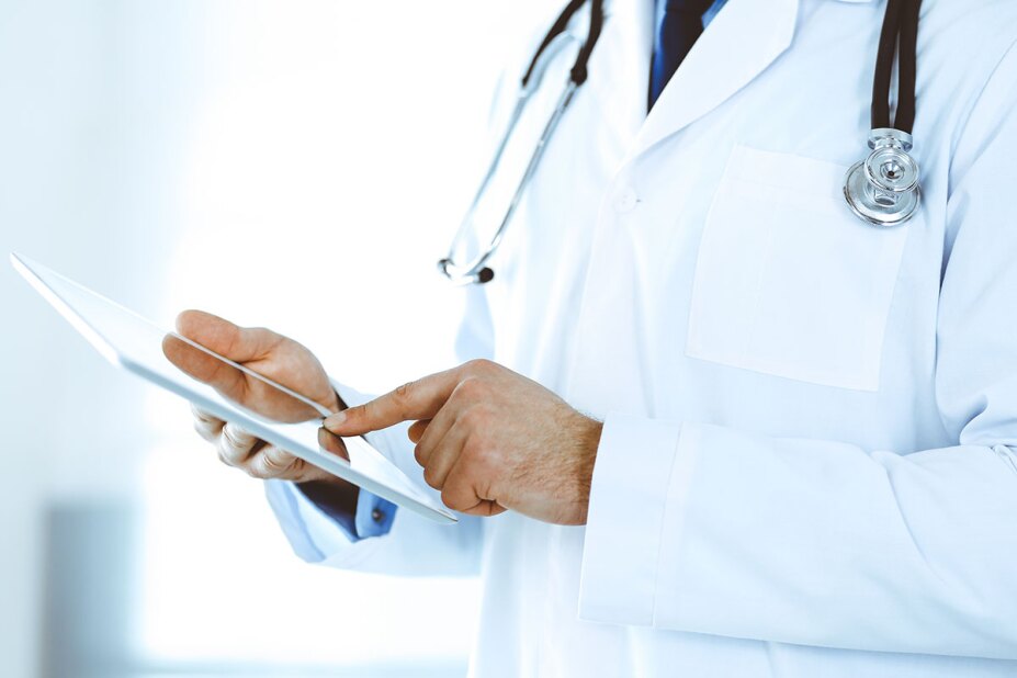 Close-up of doctor using tablet to review patient records