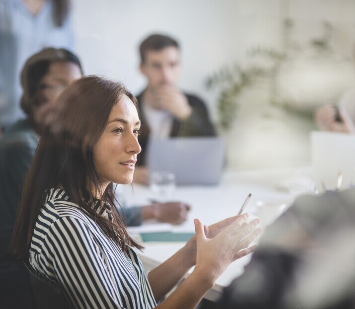 Businesswoman explaining colleagues during brainstorming session in creative office
