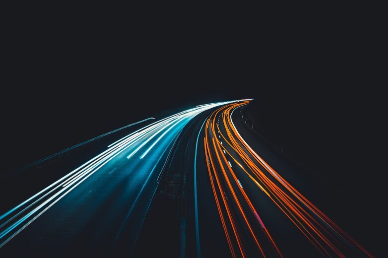 2-lane road with blurred lights from passing cars