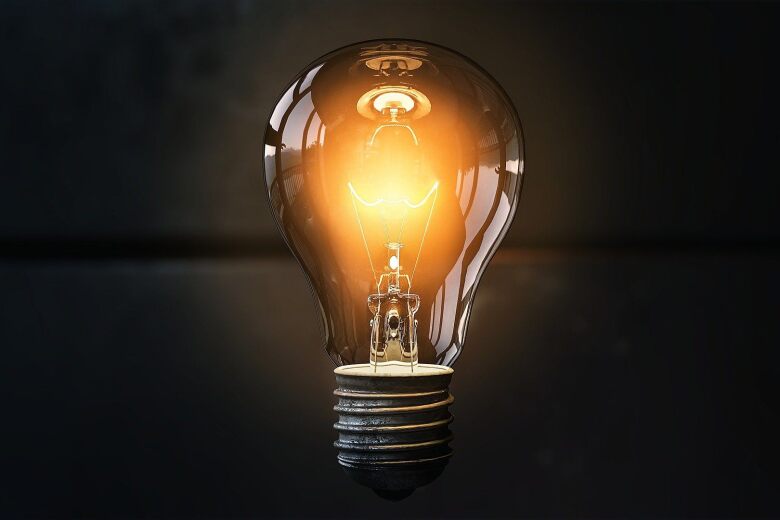 light bulb glowing orange on a dark backgorund