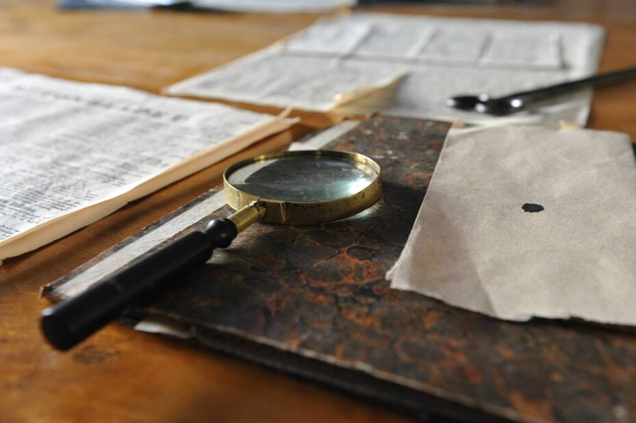 magnifying glass in focus on a table with out-of-focus papers