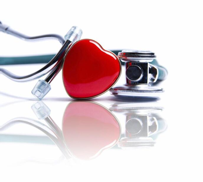 stethoscope and a red heart tin on a reflective surface