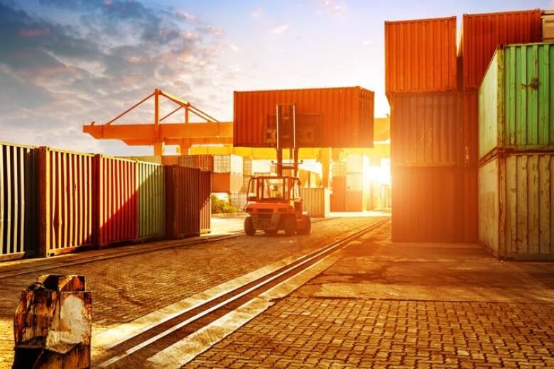 forklift carrying a container on a shipping dock