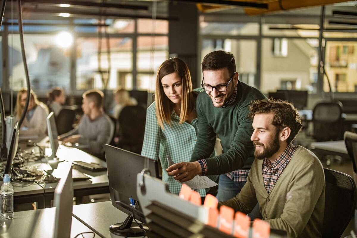 group of programmers collaborating around a computer