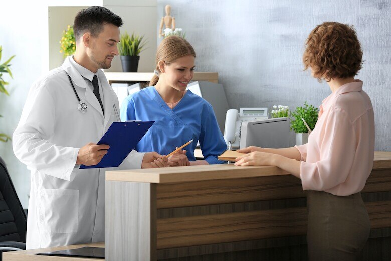 patient checking is at the reception desk in a doctor's office