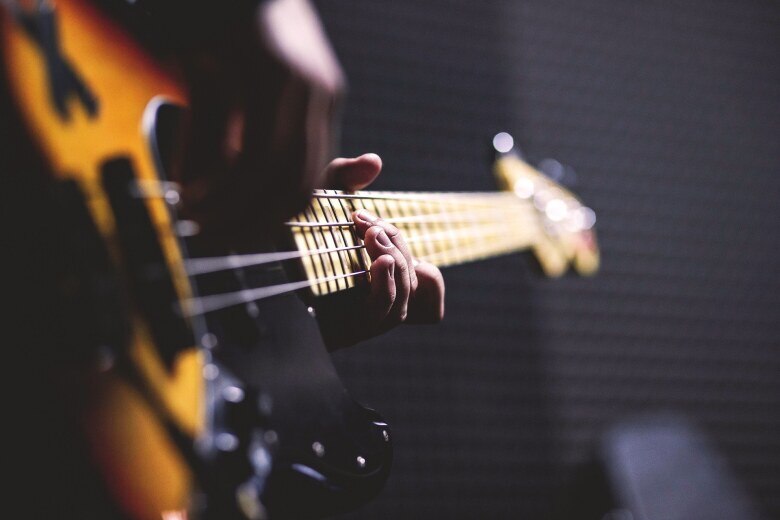 hands playing a bass guitar