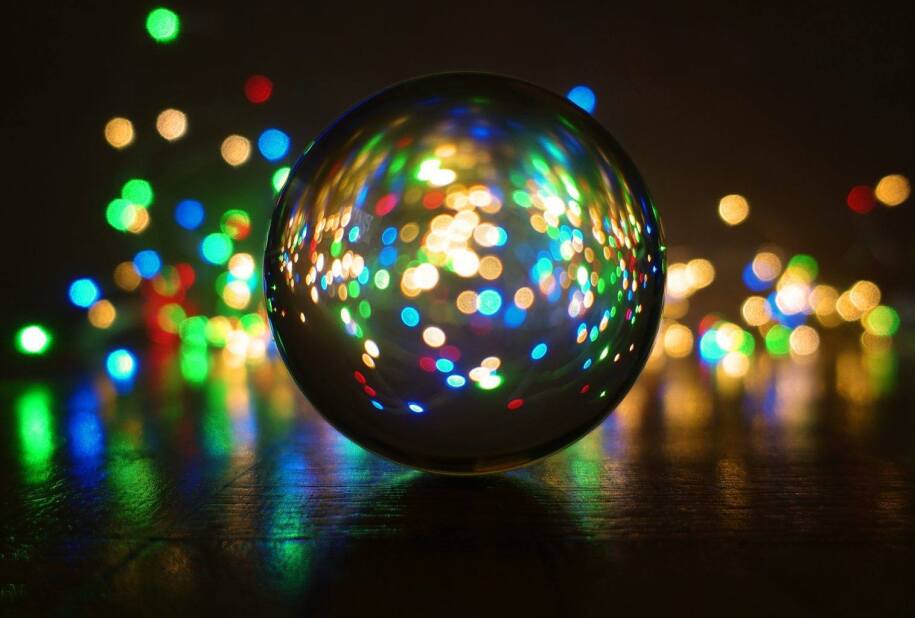 glass sphere on the floor reflecting multi-color lights from around the room