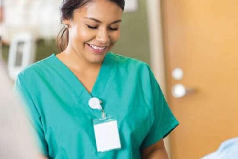 smiling nurse in green scrubs