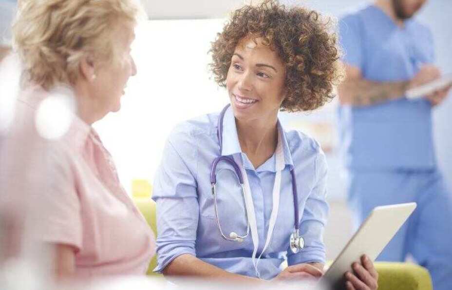 female doctor speaks with her female patient in the waiting area