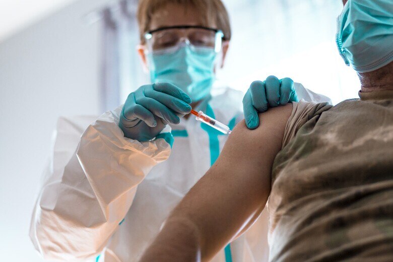 veteran receiving vaccination from doctor