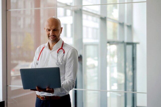 male doctor looking at his laptop