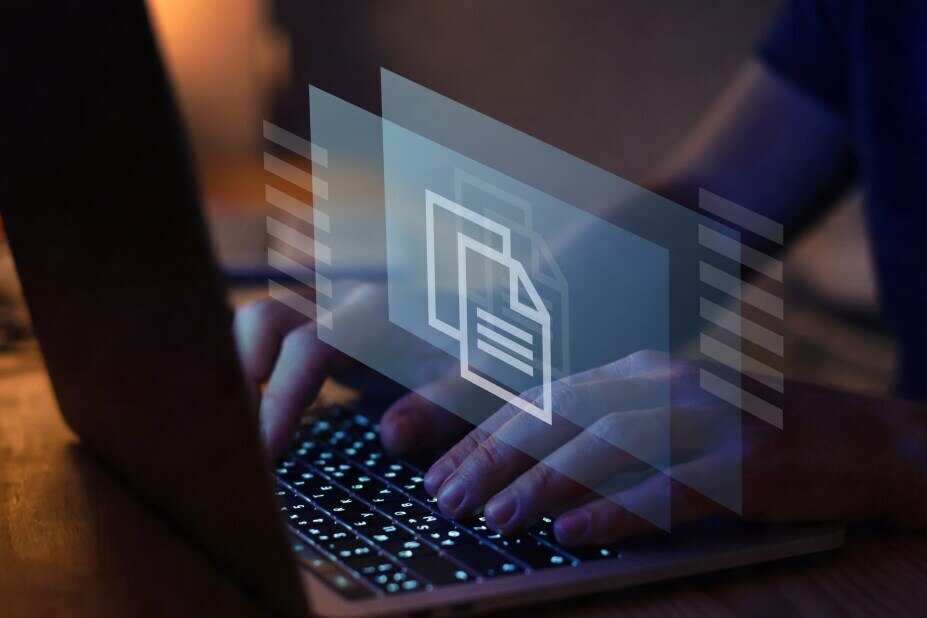 hands typing on a laptop while a download document icon hovers over the keyboard