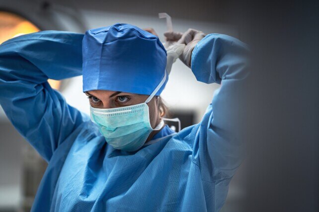 a surgeon putting a mask on to prevent infection before surgery