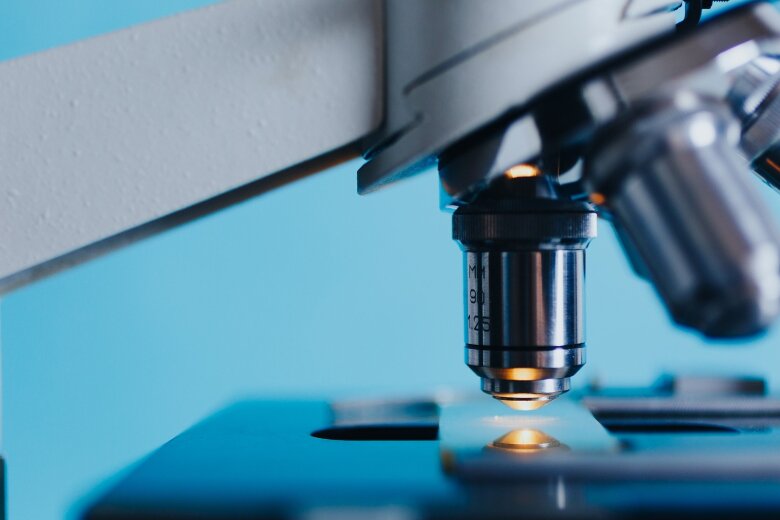 lens of a microscope pointed at a slide