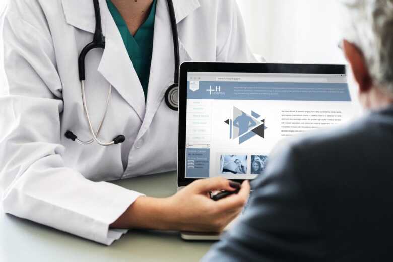 doctor showing a patient information on a laptop screen