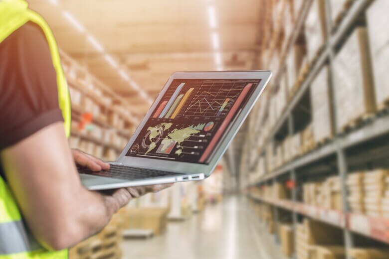 Cargo staff using computer laptop to monitor distribution flow control inventory products warehouse shipping