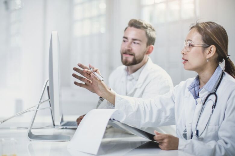 Doctor scientists looking at computer monitor