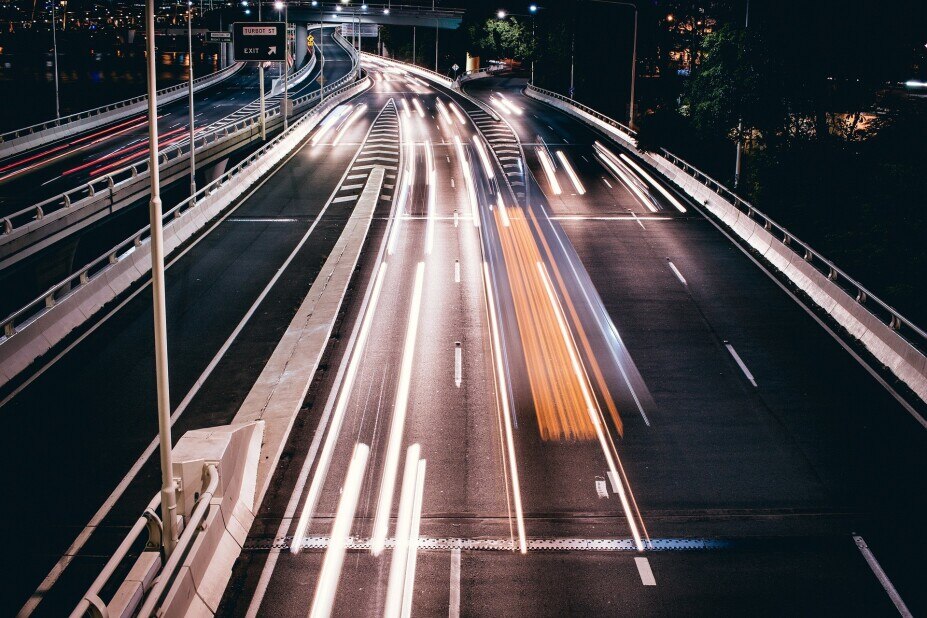 slow shutter speed image of a busy highway showing only the blurred lights of the passing cars