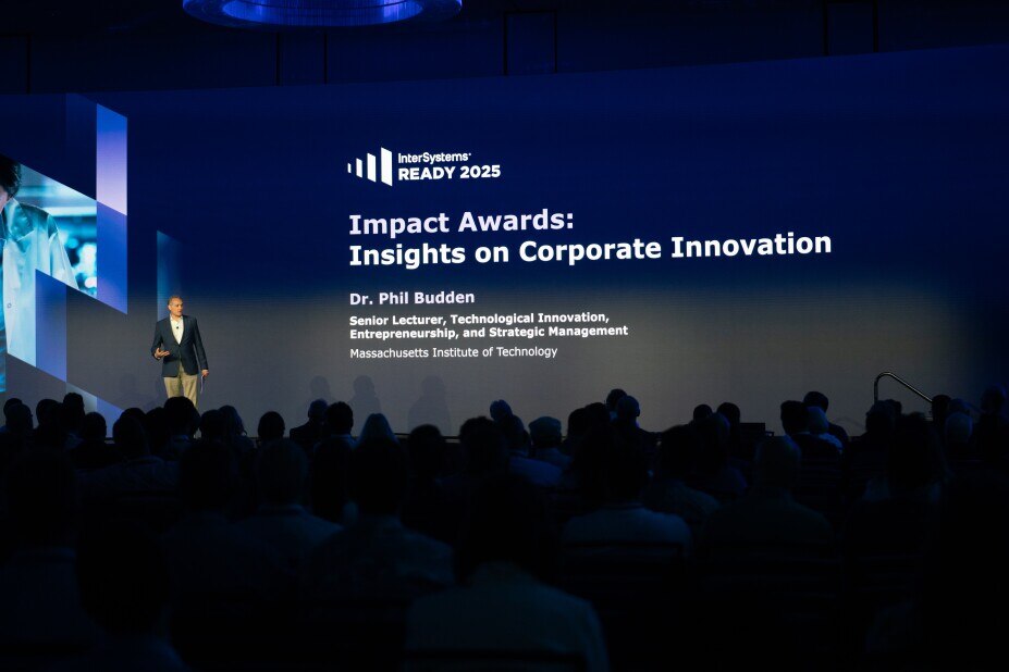 Dr. Phil Budden presents on the Ready2025 stage about the Impact Awards