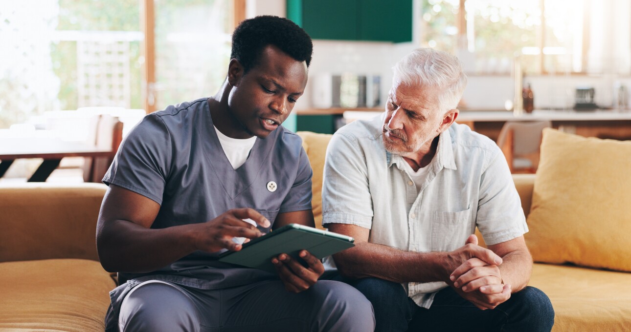 Nurse, elderly man and talk with tablet on sofa for healthcare, communication or consultation it home