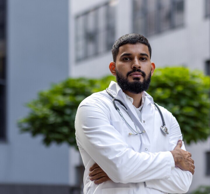 Young bearded male doctor standing in a white coat