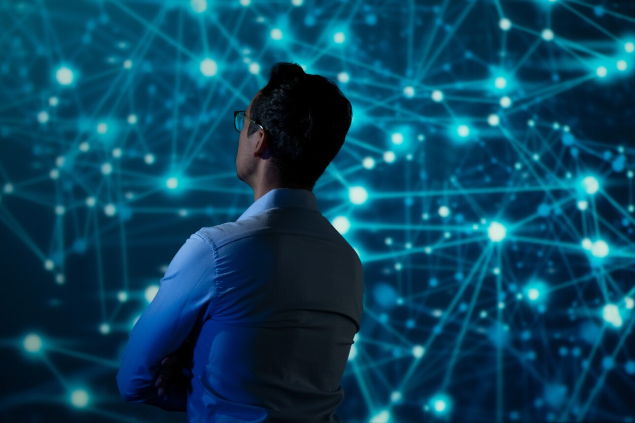 IT Specialist using tablet computer in front of big screen