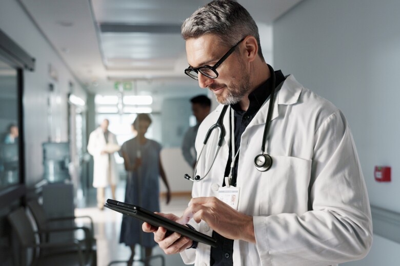 Doctor in hospital and tablet for medical information, typing and management of online charts or results.
