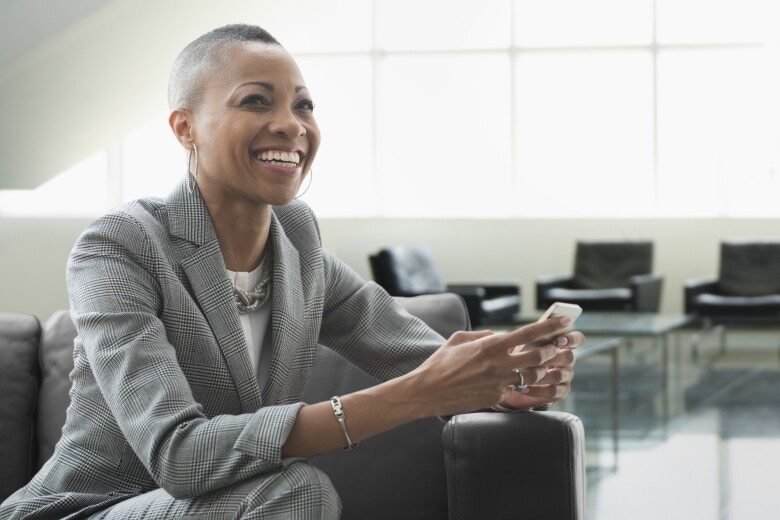 business woman with warm smile using her mobile phone
