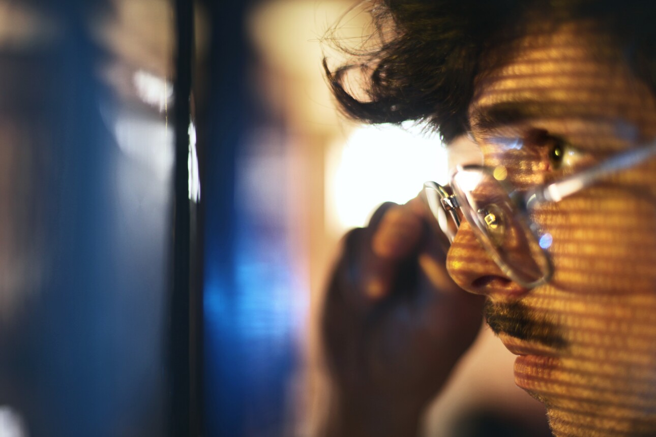 Portrait of man looking on blue screen lit with binary code