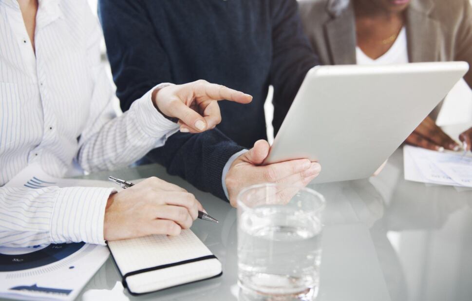 trio of healthcare professionals reviewing and analyzing data on a tablet