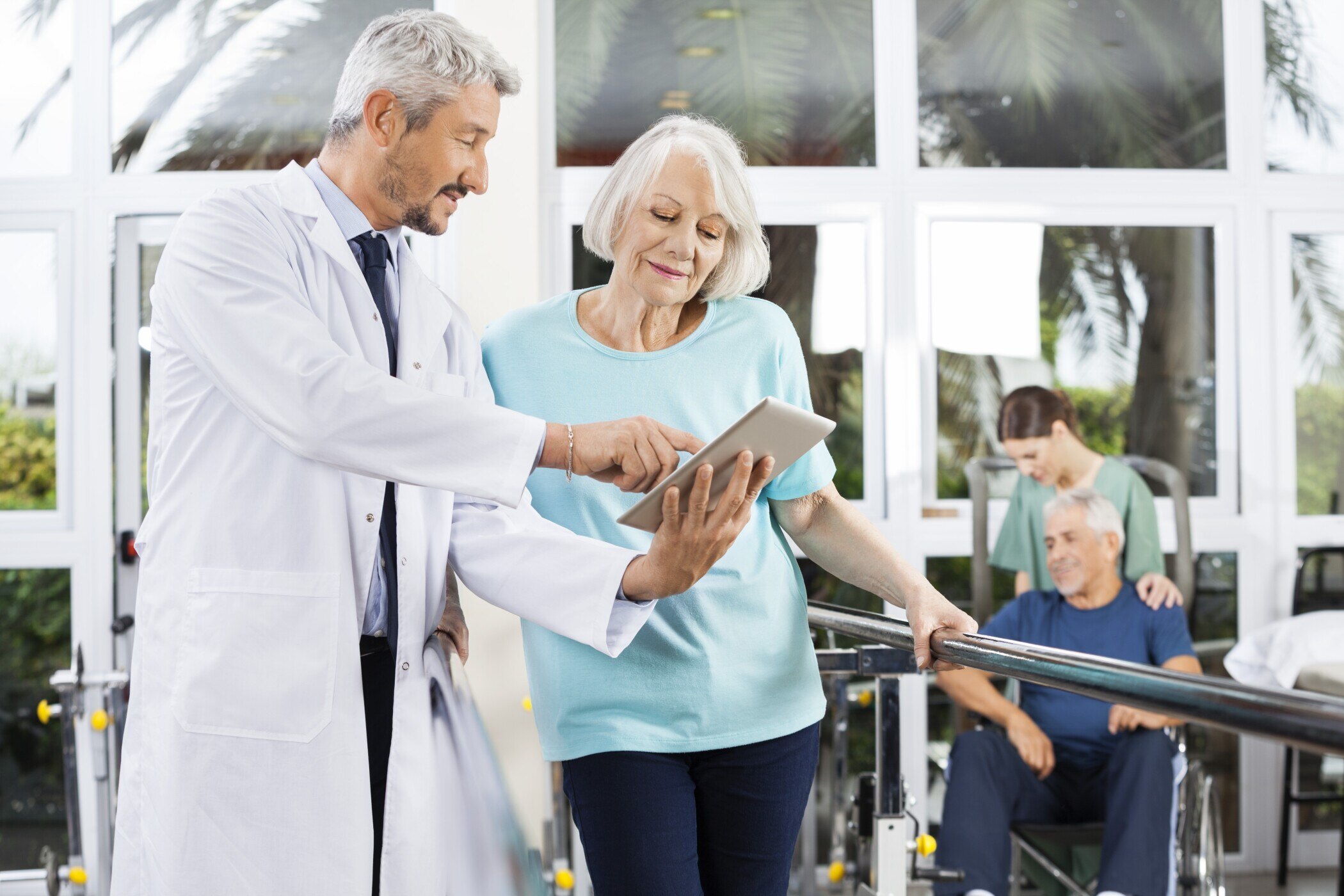 doctor-looking-at-tablet-with-patient
