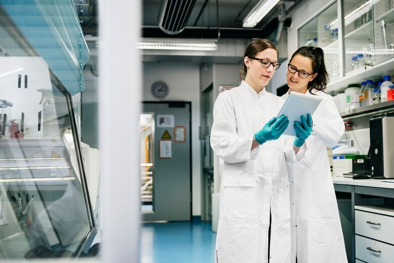doctors working in a laboratory and studying data on a tablet