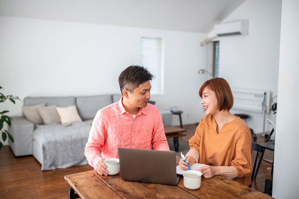 couple seated at a table working on their laptop