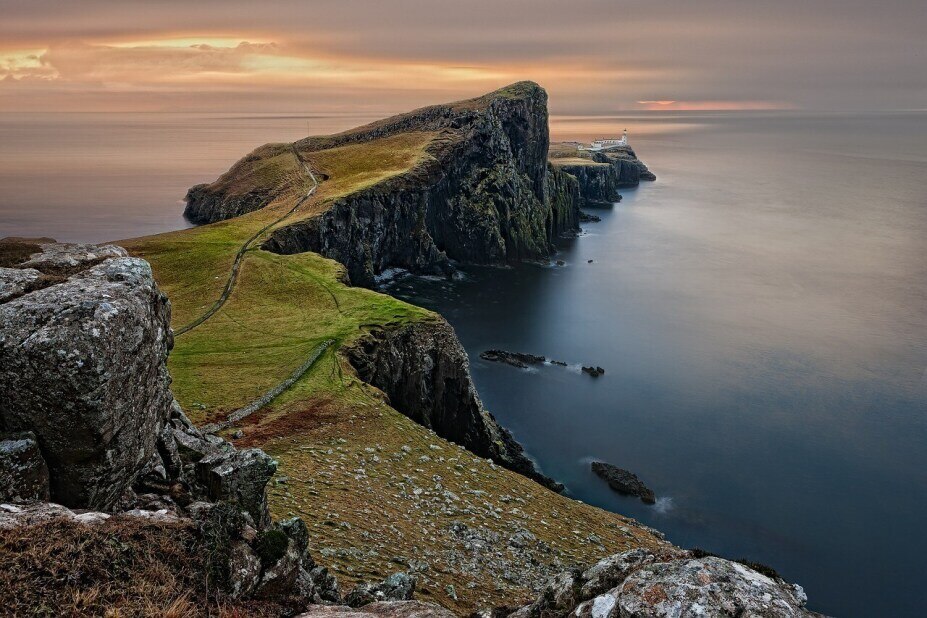 rocky, grass-covered cliffs in Scotland jut out into the sea