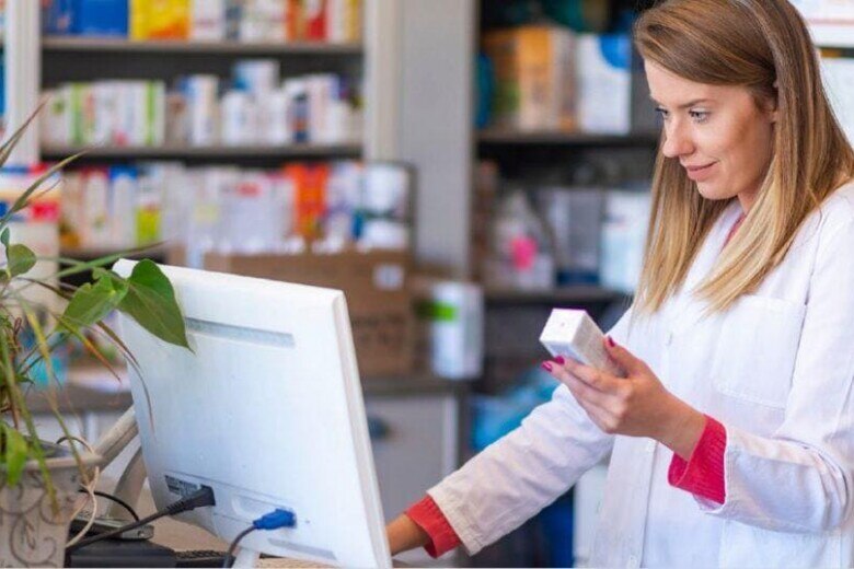 female pharmacist checking medication on computer