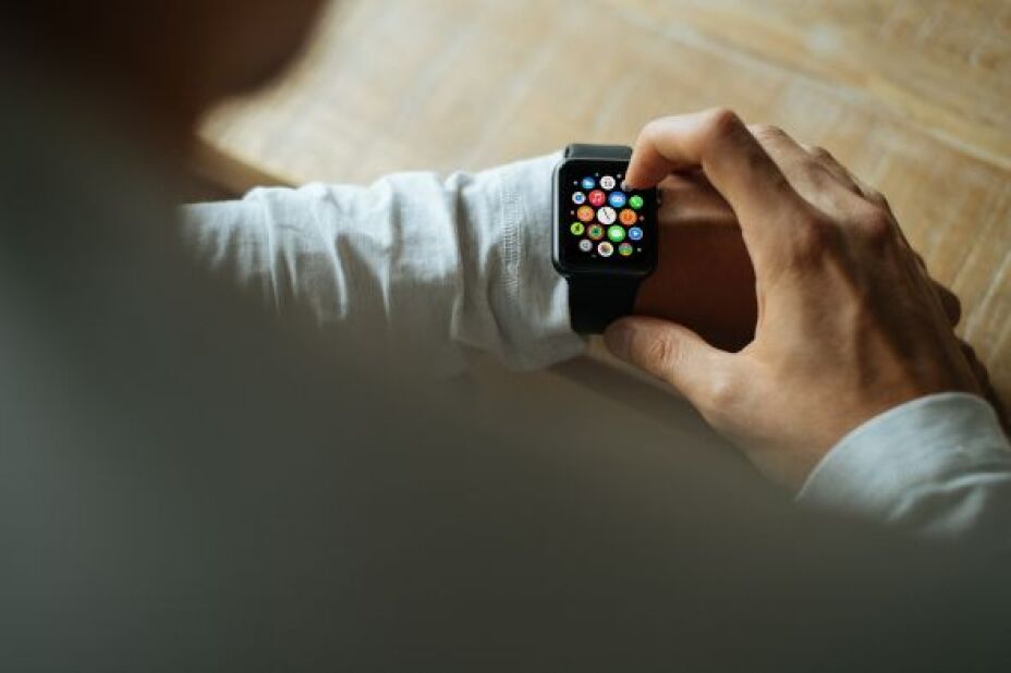 person looking at smartwatch with various apps